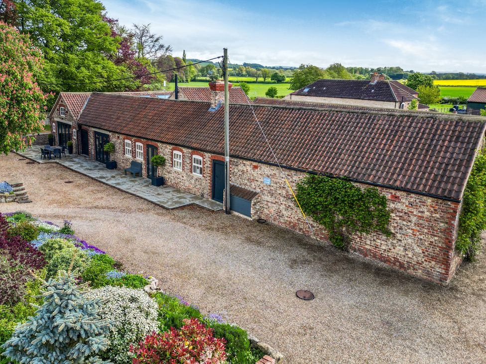 An outdoor view of a building with garden and seating area at Sykes Lodge in Malton