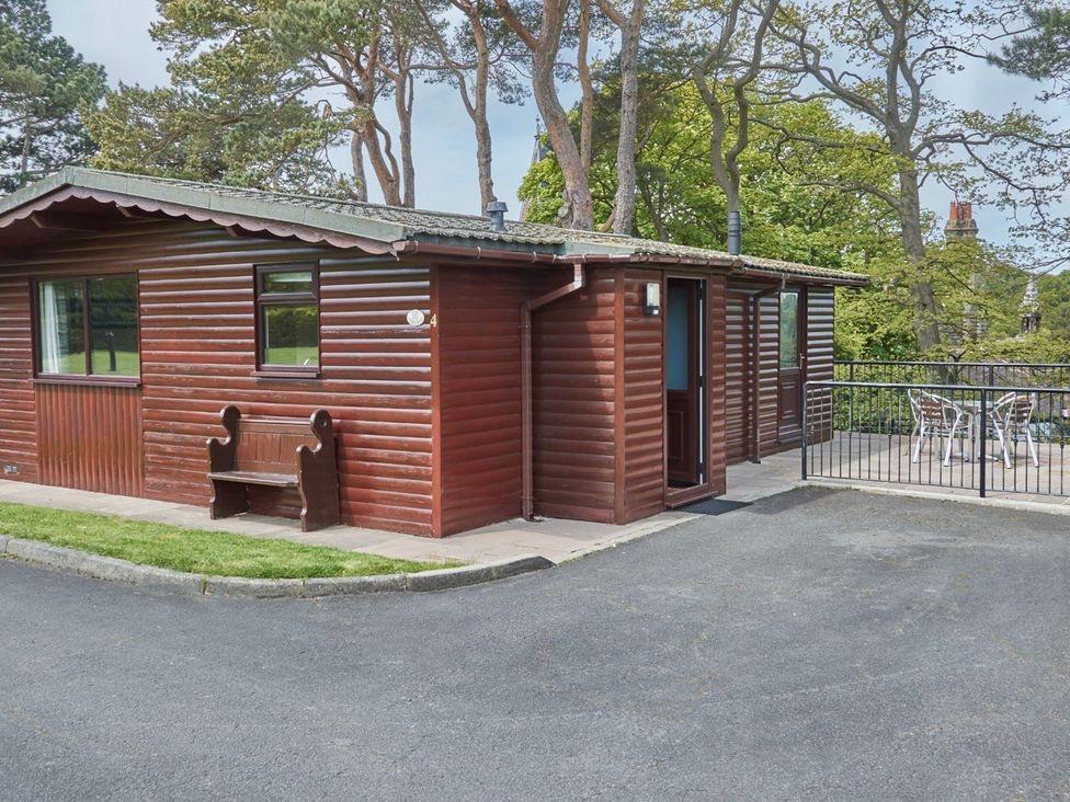 A wooden lodge with a bench outside at Daffodil Lodge in Saltburn-by-the-Sea