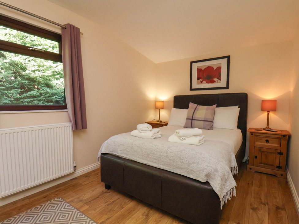 A bedroom with a bed and nightstands at Orchid Lodge in Saltburn-by-the-Sea