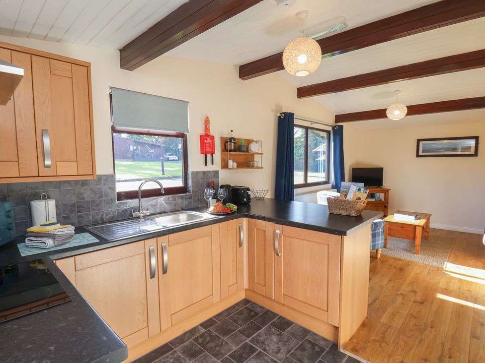 A kitchen with wooden cabinets and a sink at Foxglove Lodge in Saltburn-By-The-Sea