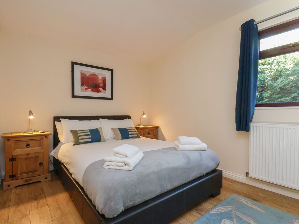 A bedroom with a bed and nightstands at Foxglove Lodge in Saltburn-By-The-Sea