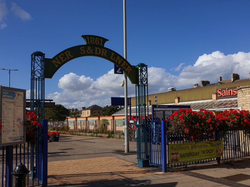 An archway with a sign and flowers at the entrance to a store in Saltburn-By-The-Sea