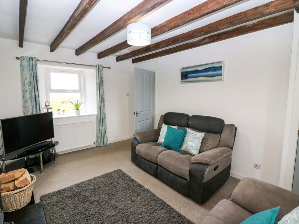A living room with a television and sofas at Birds Nest in Jedburgh