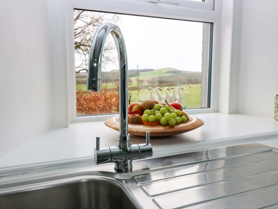 A kitchen with a sink and faucet by the window at Birds Nest in Jedburgh