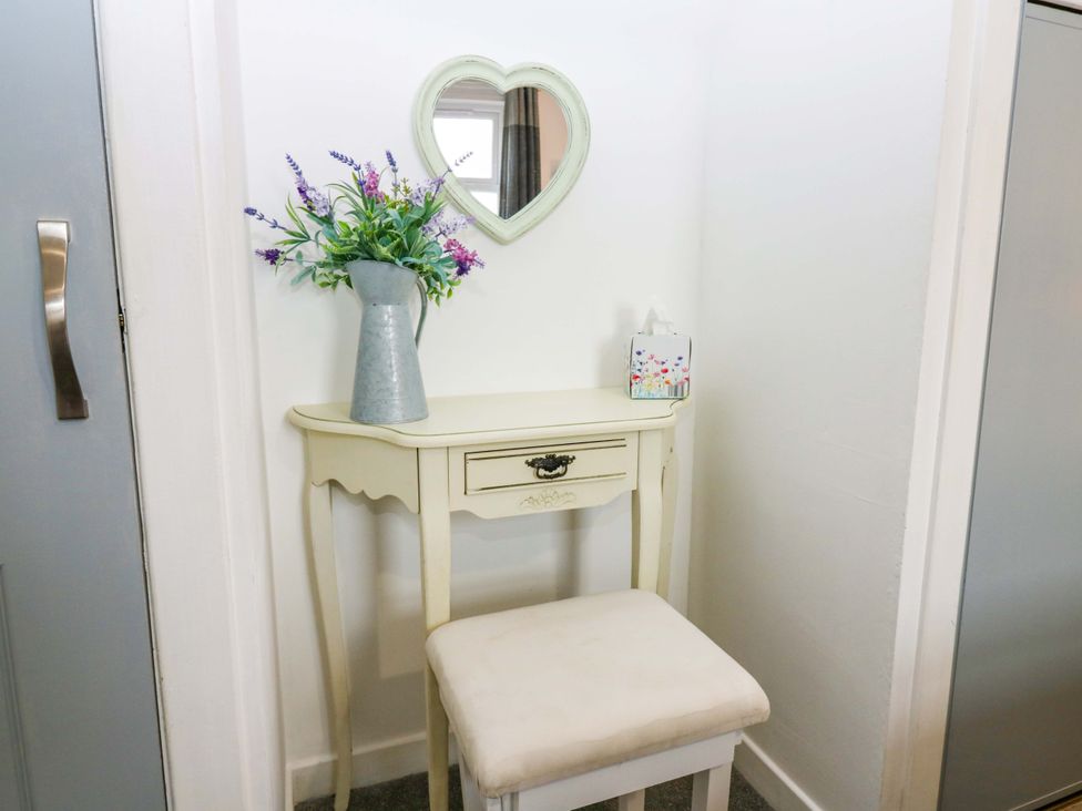 A hallway with a table and mirror at Birds Nest in Jedburgh
