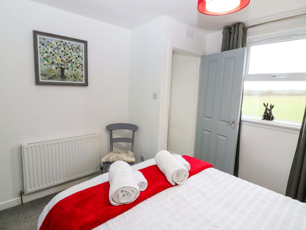 A bedroom with a bed and chair at Birds Nest in Jedburgh