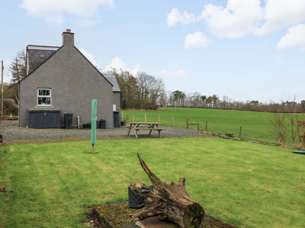 A grey house and lawn with a seating area at Birds Nest in Jedburgh