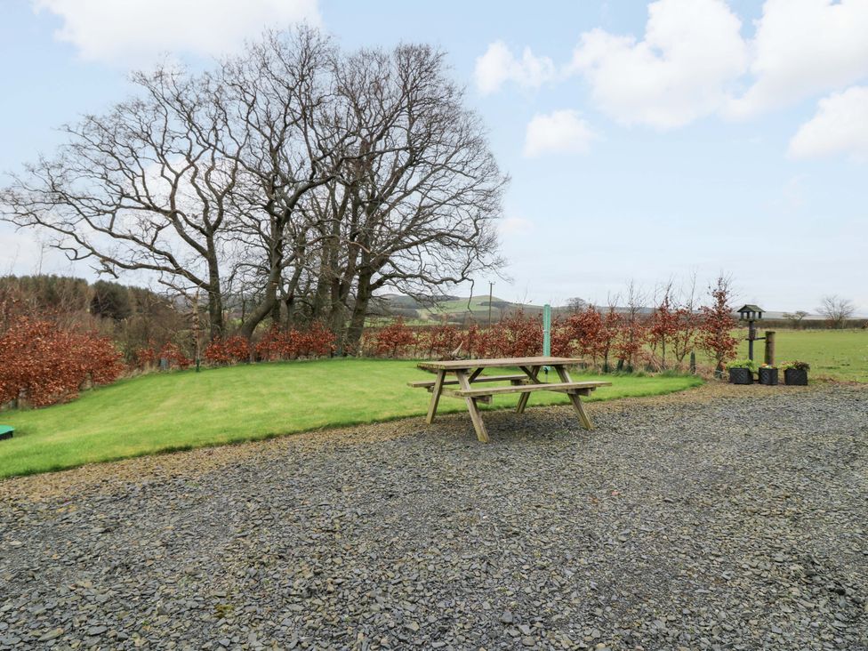 A garden with a picnic table and a tree at Birds Nest in Jedburgh