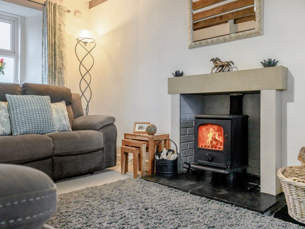 A living room with a fireplace and sofa at Birds Nest in Jedburgh