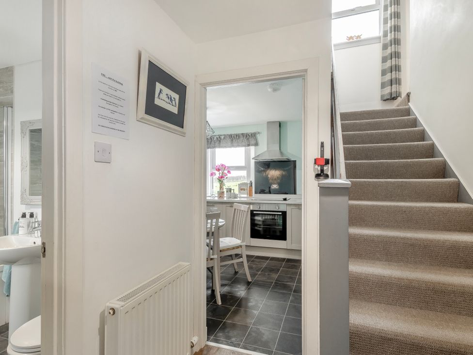 A hallway with access to a kitchen and staircase at Birds Nest in Jedburgh