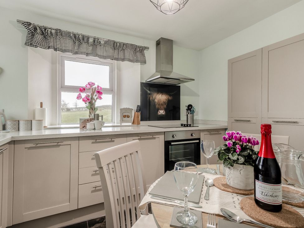 A kitchen with a table set for dining at Birds Nest in Jedburgh