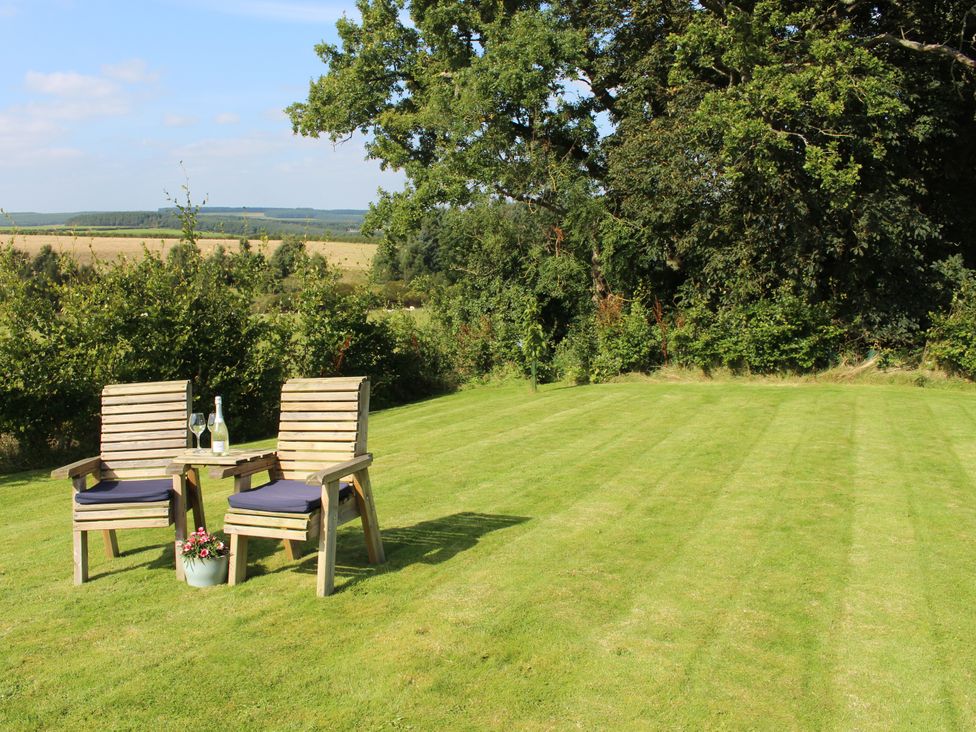 A garden with two chairs and a table at Birds Nest in Jedburgh