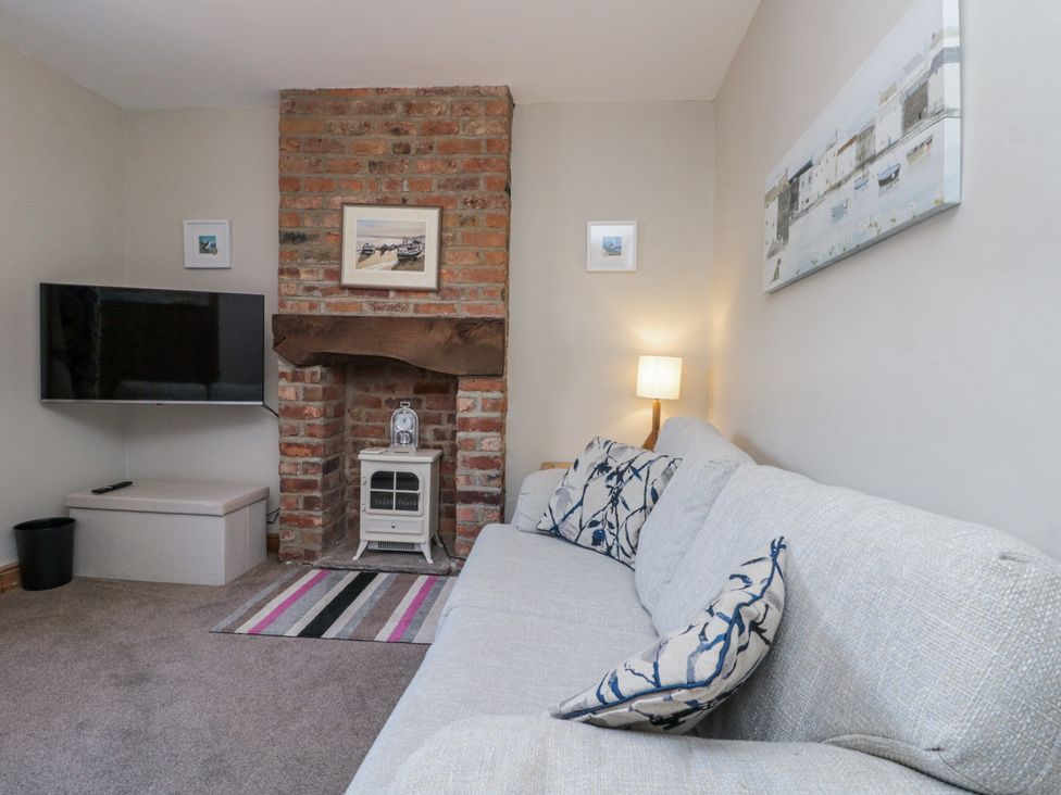 A living room with a sofa and television at Chapel Cottage in Filey