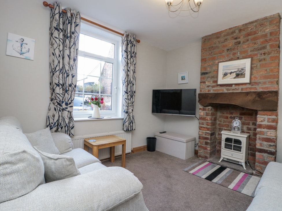 A living room with a sofa and television at Chapel Cottage in Filey