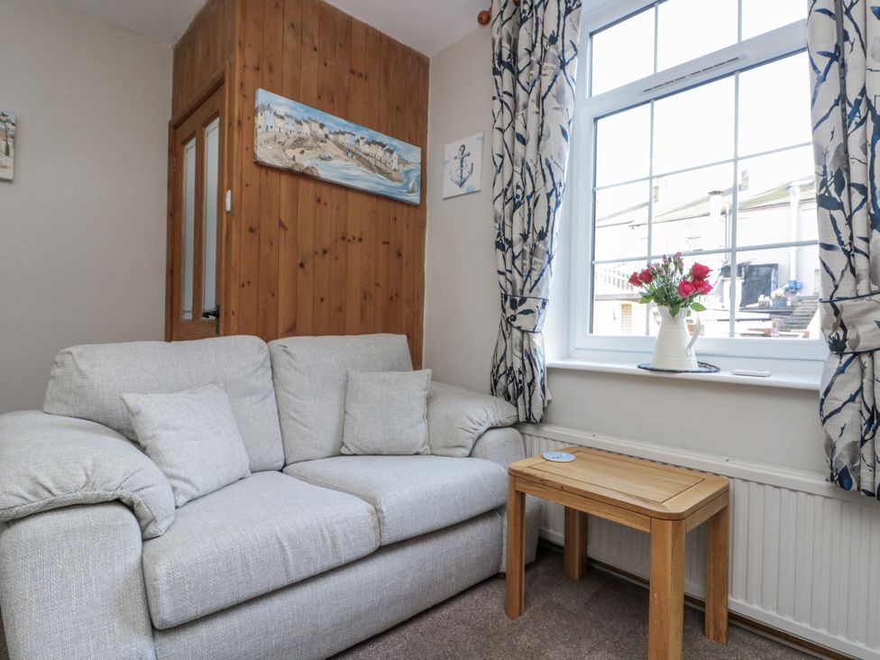 A living room with a sofa and wooden table at Chapel Cottage in Filey