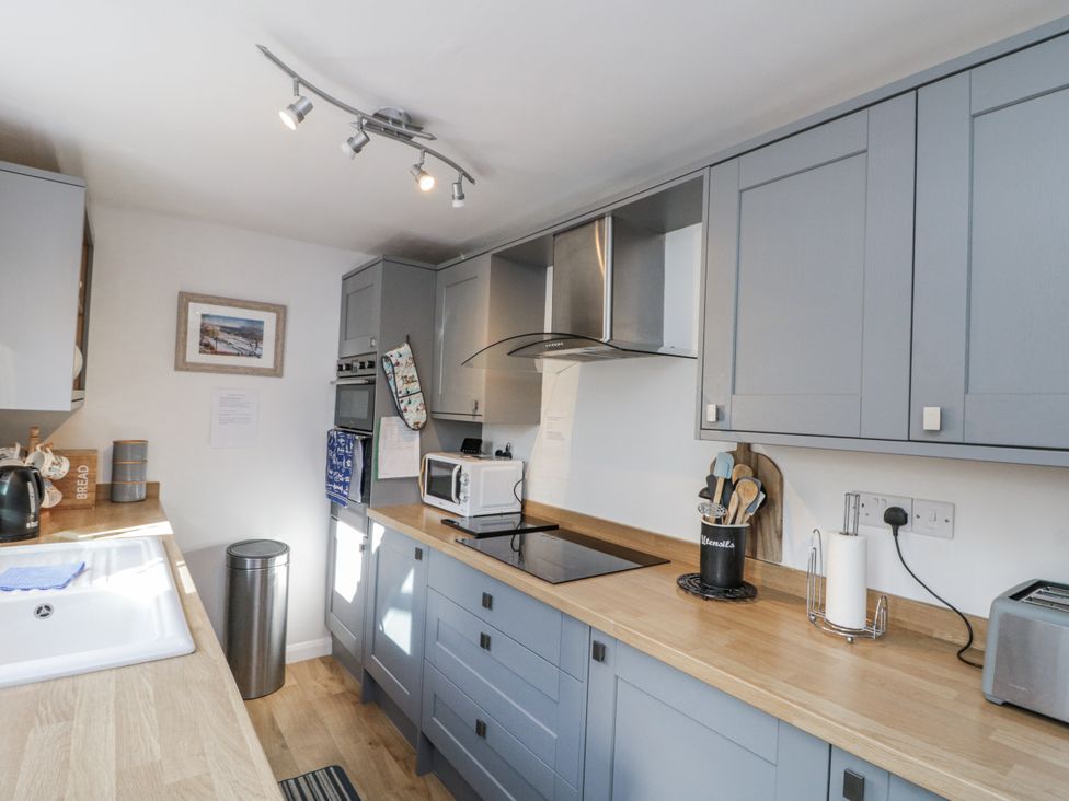 A kitchen with cabinets and appliances at Chapel Cottage in Filey