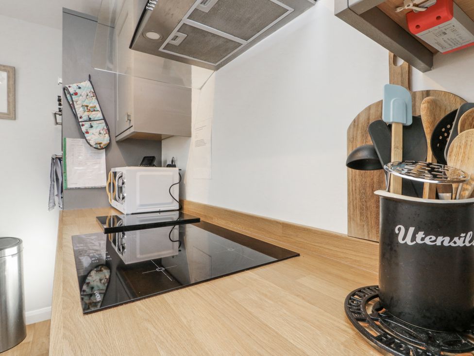 A kitchen with a countertop, induction cooktop, and microwave at Chapel Cottage in Filey