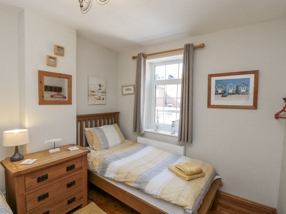 A bedroom with a bed and nightstand at Chapel Cottage in Filey