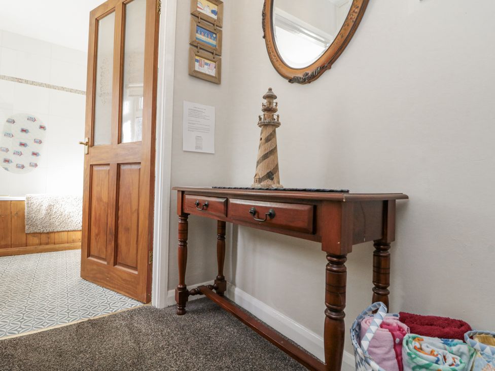 A hallway with a wooden table and lighthouse decor at Chapel Cottage in Filey