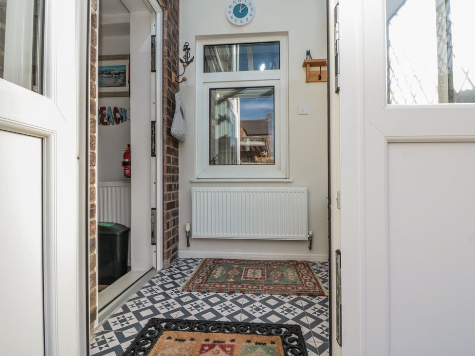 A hallway with a radiator and mat at Chapel Cottage in Filey