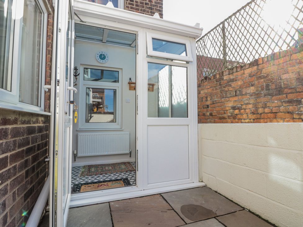 A conservatory with a door and window at Chapel Cottage in Filey