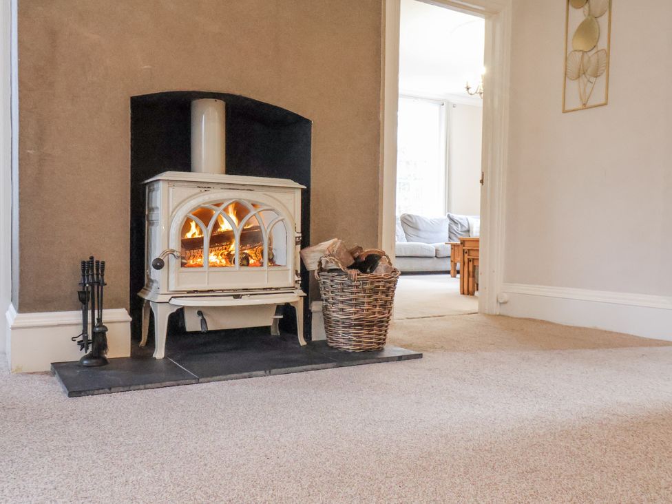 A living room with a fireplace and a wood stove at The Manor House in Scarborough