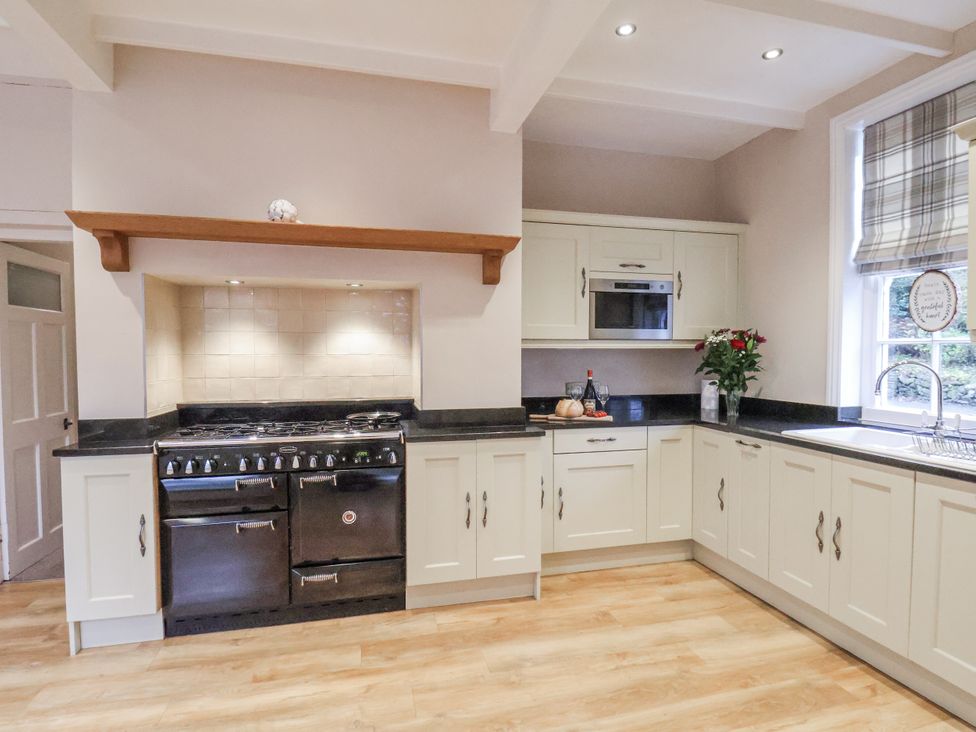 A kitchen with an oven, cabinets, and sink at The Manor House in Scarborough