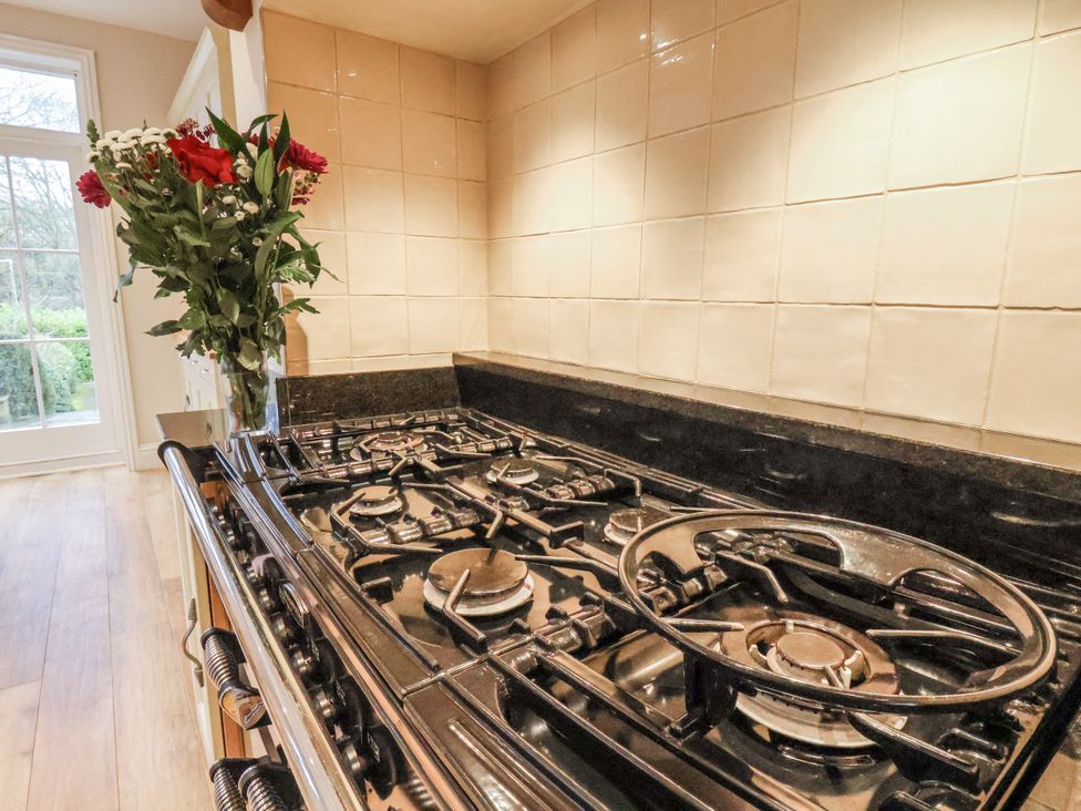 A kitchen with a gas stove and a vase of flowers at The Manor House in Scarborough