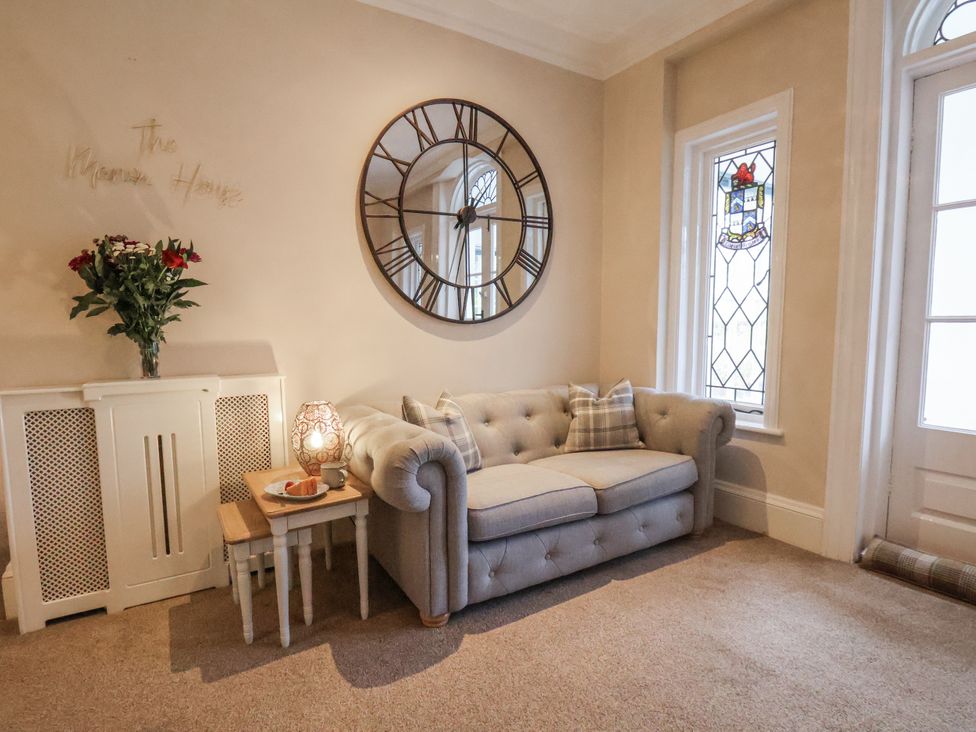 A living room with a sofa and a mirror at The Manor House in Scarborough