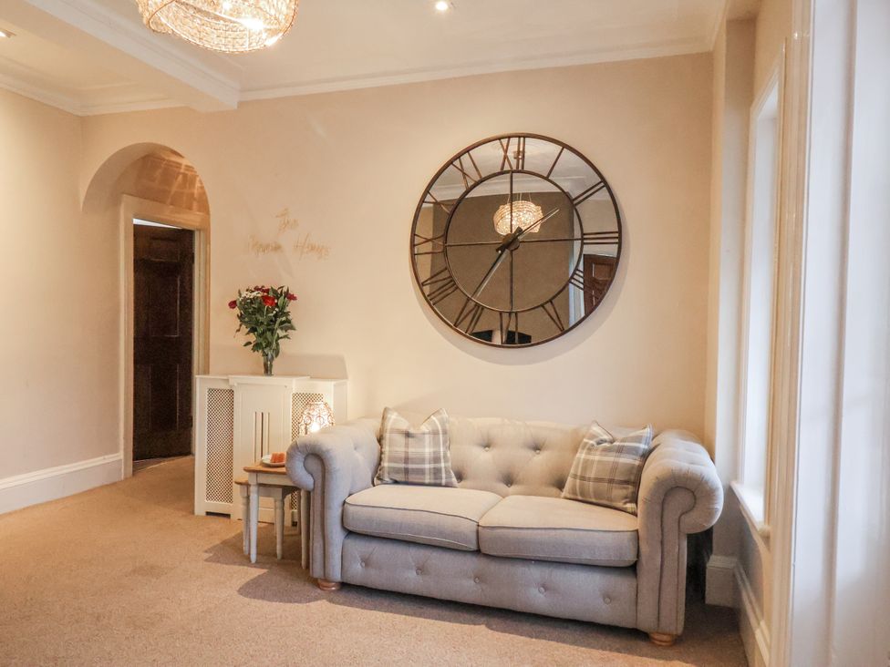 A living room with a sofa and clock at The Manor House in Scarborough