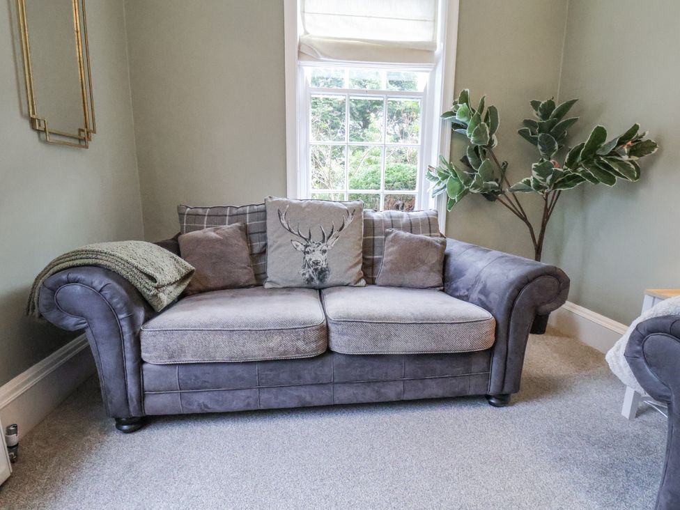A living room with a sofa and plants at The Manor House in Scarborough