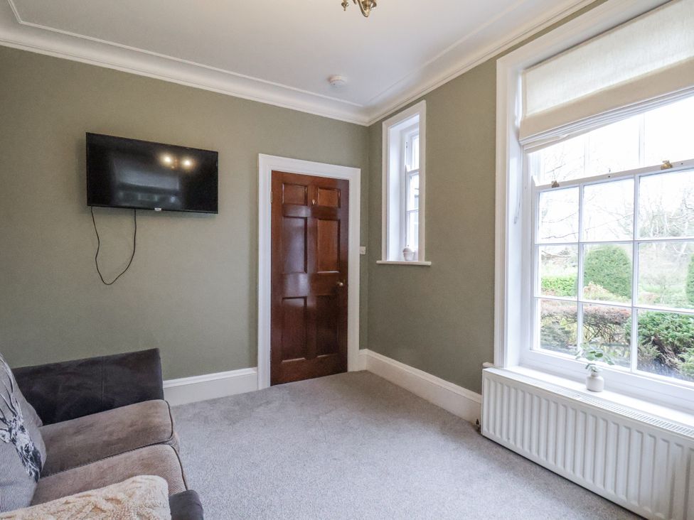 A living room with a television and sofa at The Manor House in Scarborough