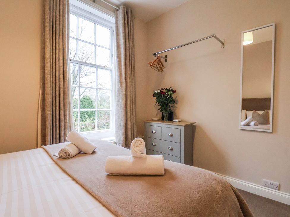 A bedroom with a bed and dresser at The Manor House in Scarborough