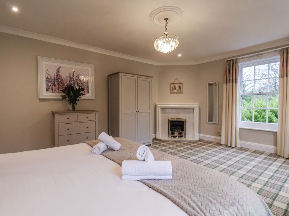 A bedroom with a bed, wardrobe, and window at The Manor House in Scarborough