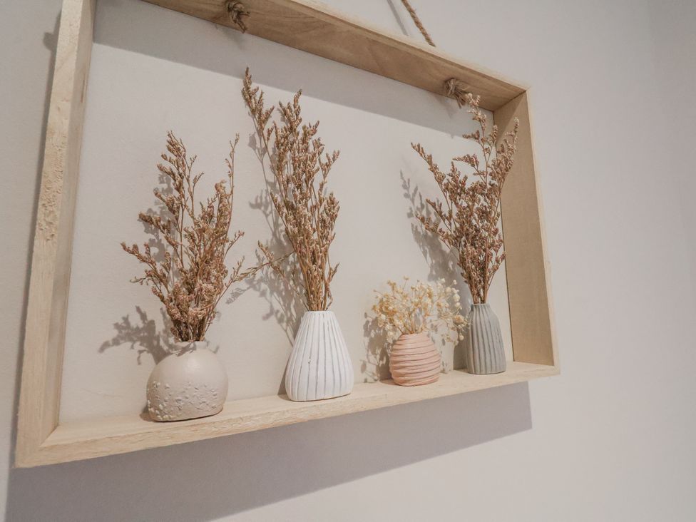 Dried flowers in vases displayed in a wooden frame