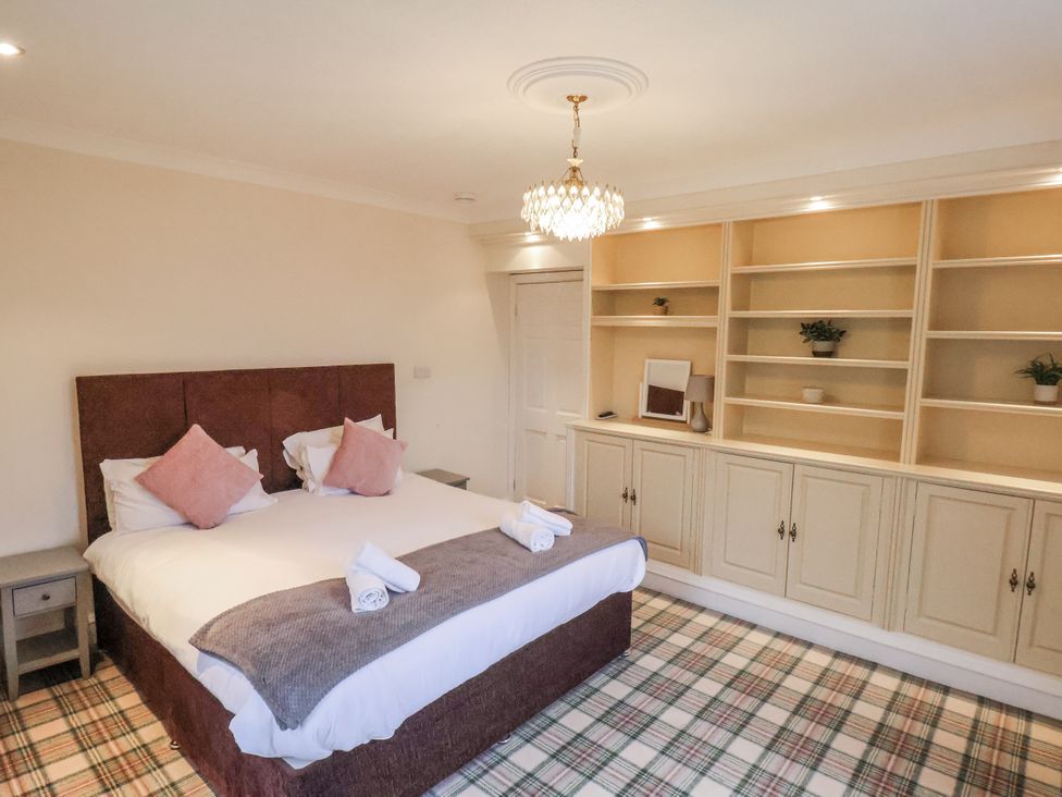 A bedroom with a bed and shelves at The Manor House in Scarborough