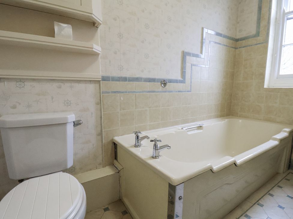 A bathroom with a bathtub and toilet at The Manor House in Scarborough