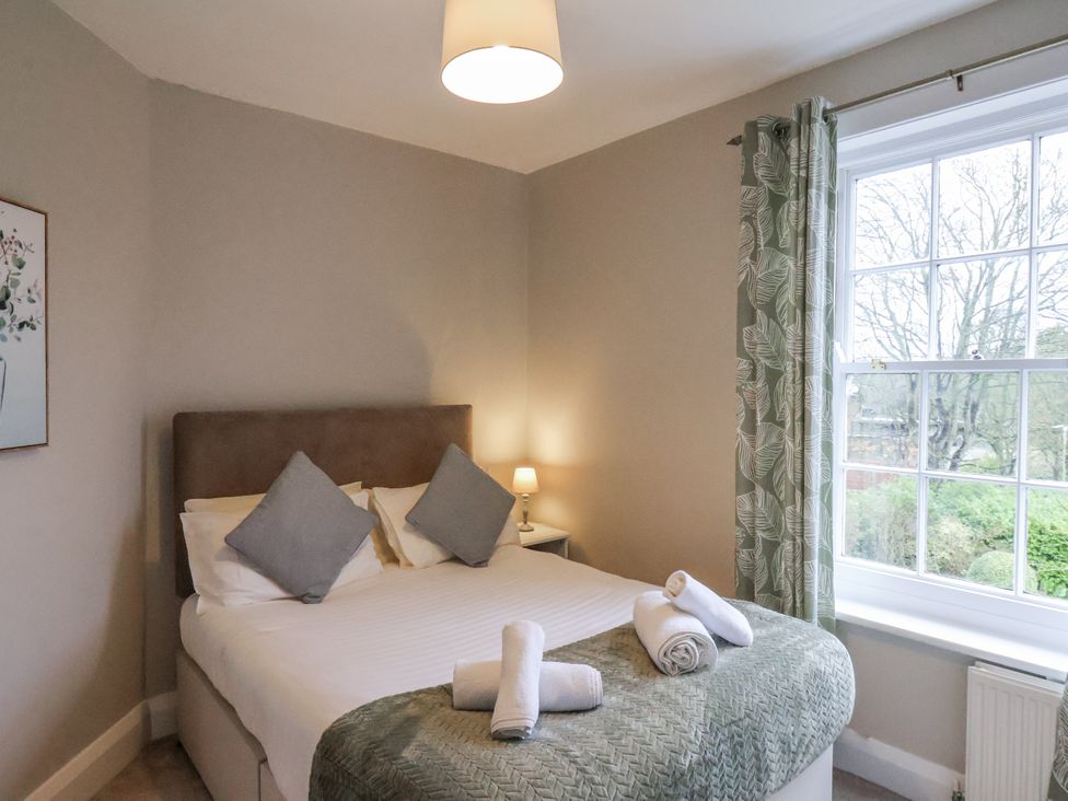 A bedroom with a bed and window at The Manor House in Scarborough