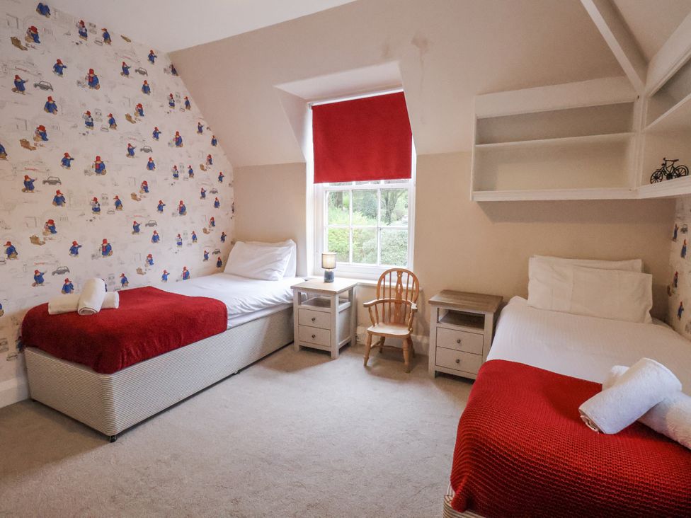 A bedroom with three beds and a window at The Manor House in Scarborough