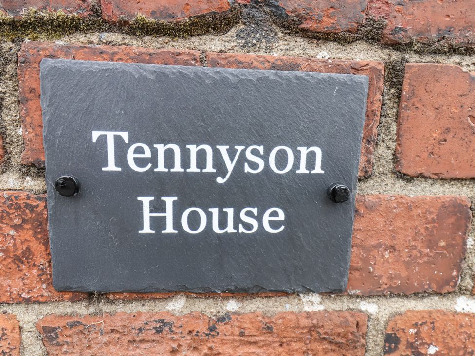 A sign on a brick wall reading Tennyson House in Scarborough