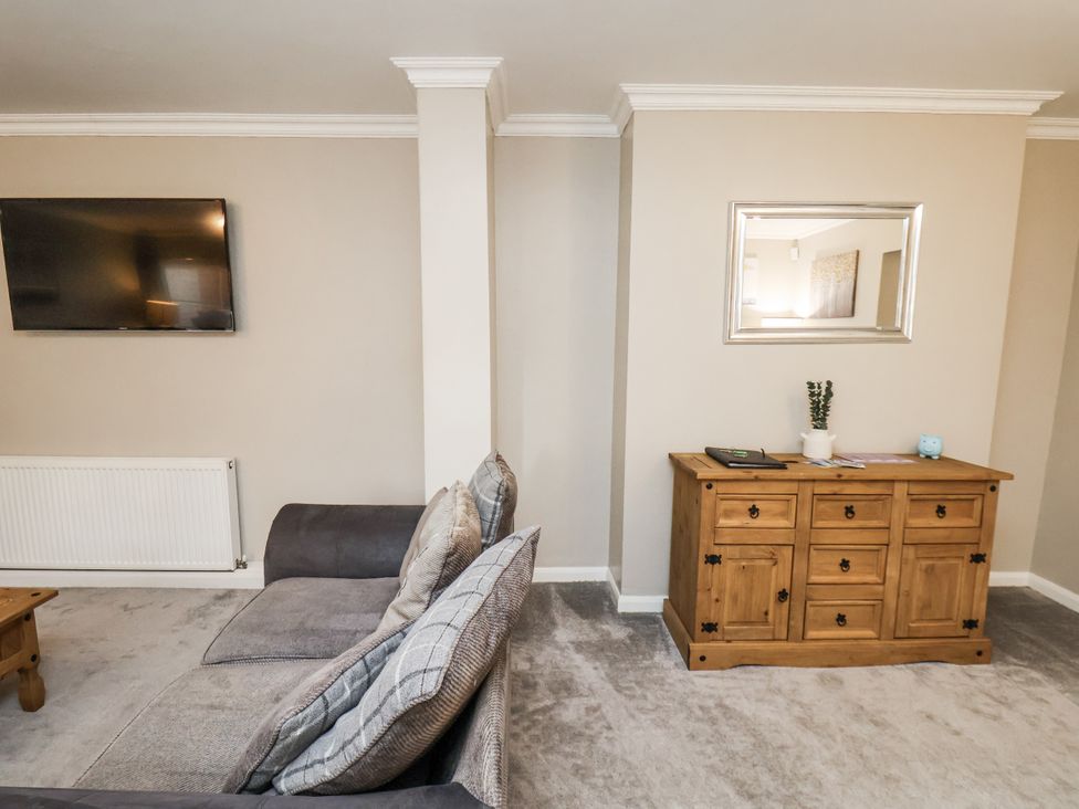A living room with a sofa and television at Tennyson House in Scarborough