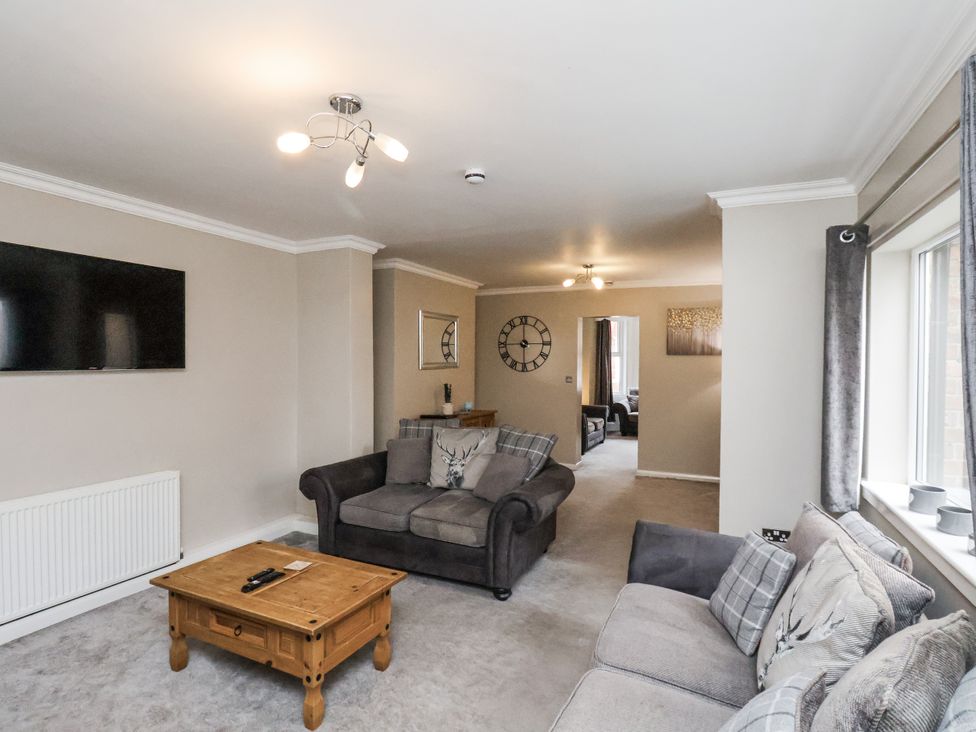 A living room with a tv and seating area at Tennyson House in Scarborough
