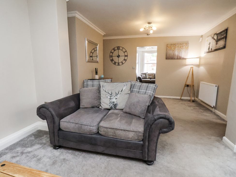 A living room with a sofa and clock at Tennyson House in Scarborough
