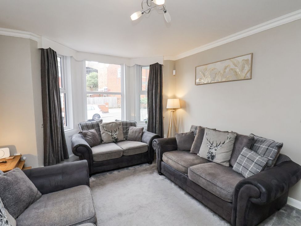 A living room with sofas and a lamp at Tennyson House in Scarborough