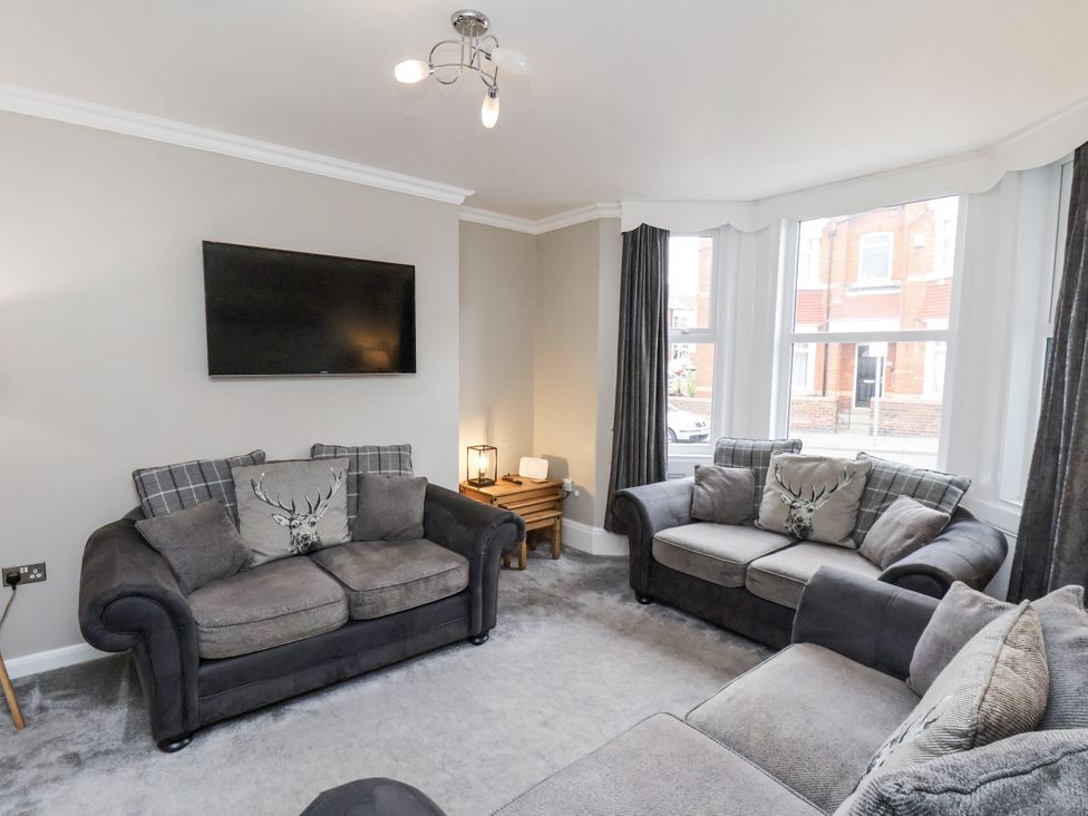 A living room with a sofa and television at Tennyson House in Scarborough