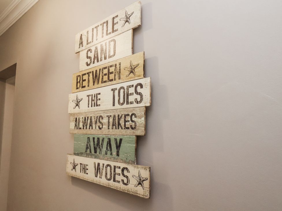 A wooden sign with text on a wall at Tennyson House in Scarborough