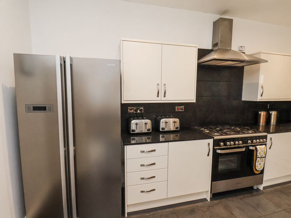A kitchen with a refrigerator, oven, and toaster at Tennyson House in Scarborough
