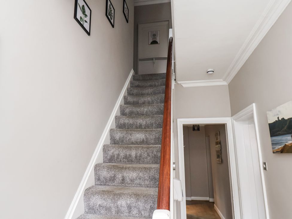 A staircase with pictures on the wall at Tennyson House in Scarborough