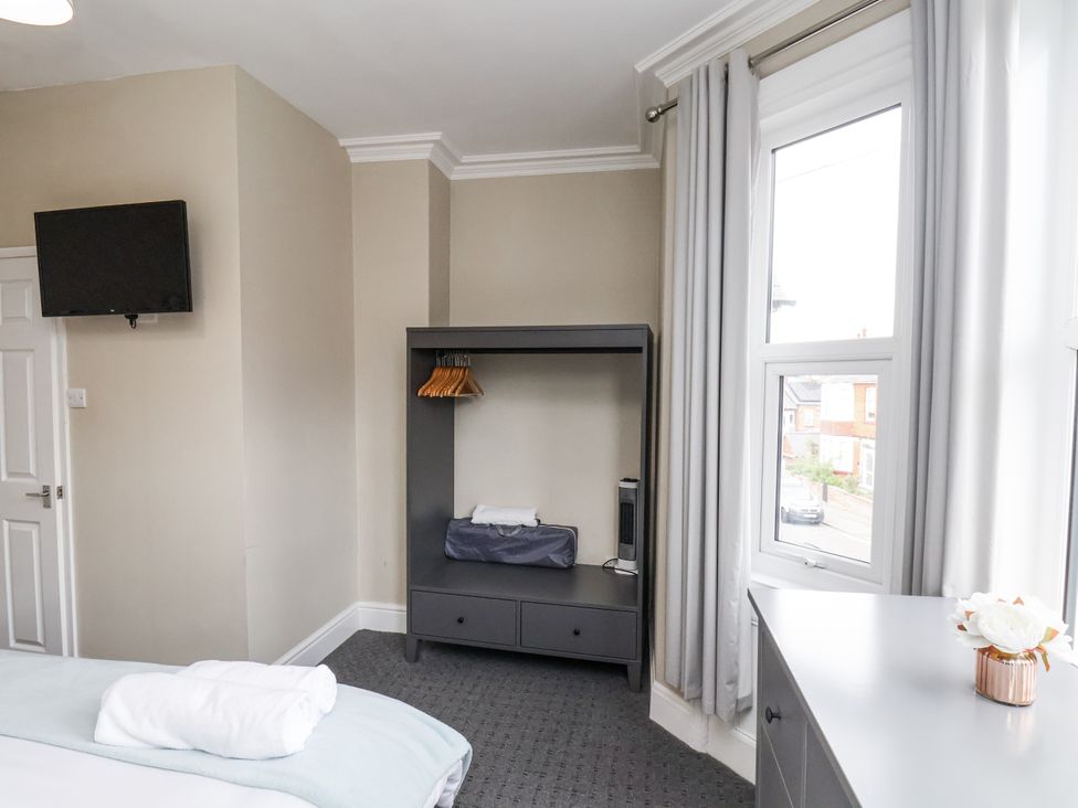 A bedroom with a television and wardrobe at Tennyson House in Scarborough