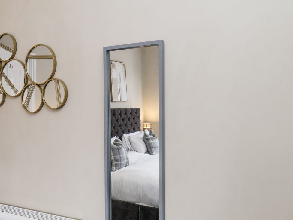 A bedroom with a bed and decorative mirrors at Tennyson House in Scarborough